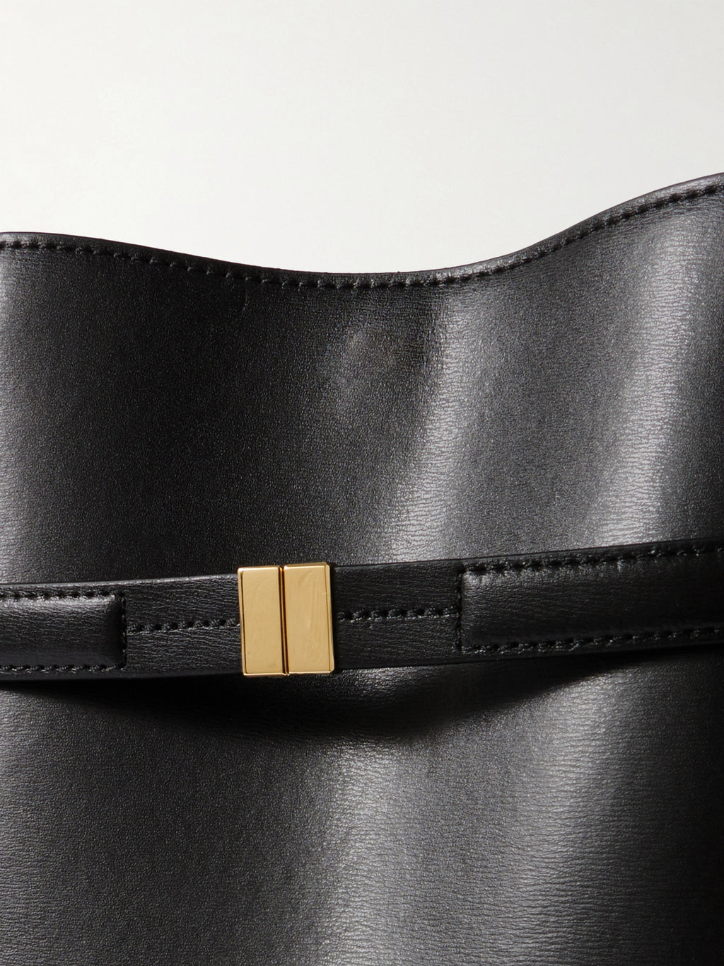 black bucket bag gold hardware detail women leather close up