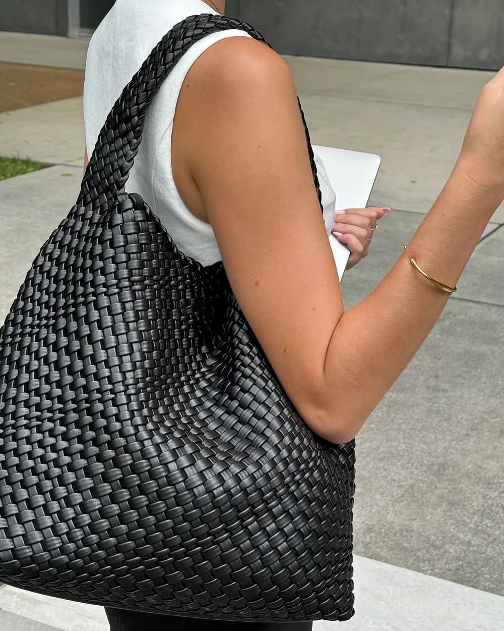 woman carrying oversized black woven tote bag on shoulder street style - black - tote bag