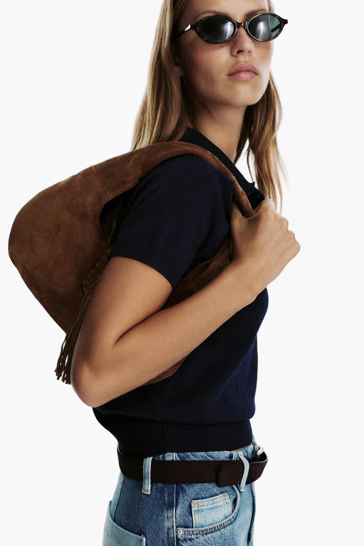 women carrying caramel fringe hobo bag shoulder full length street style