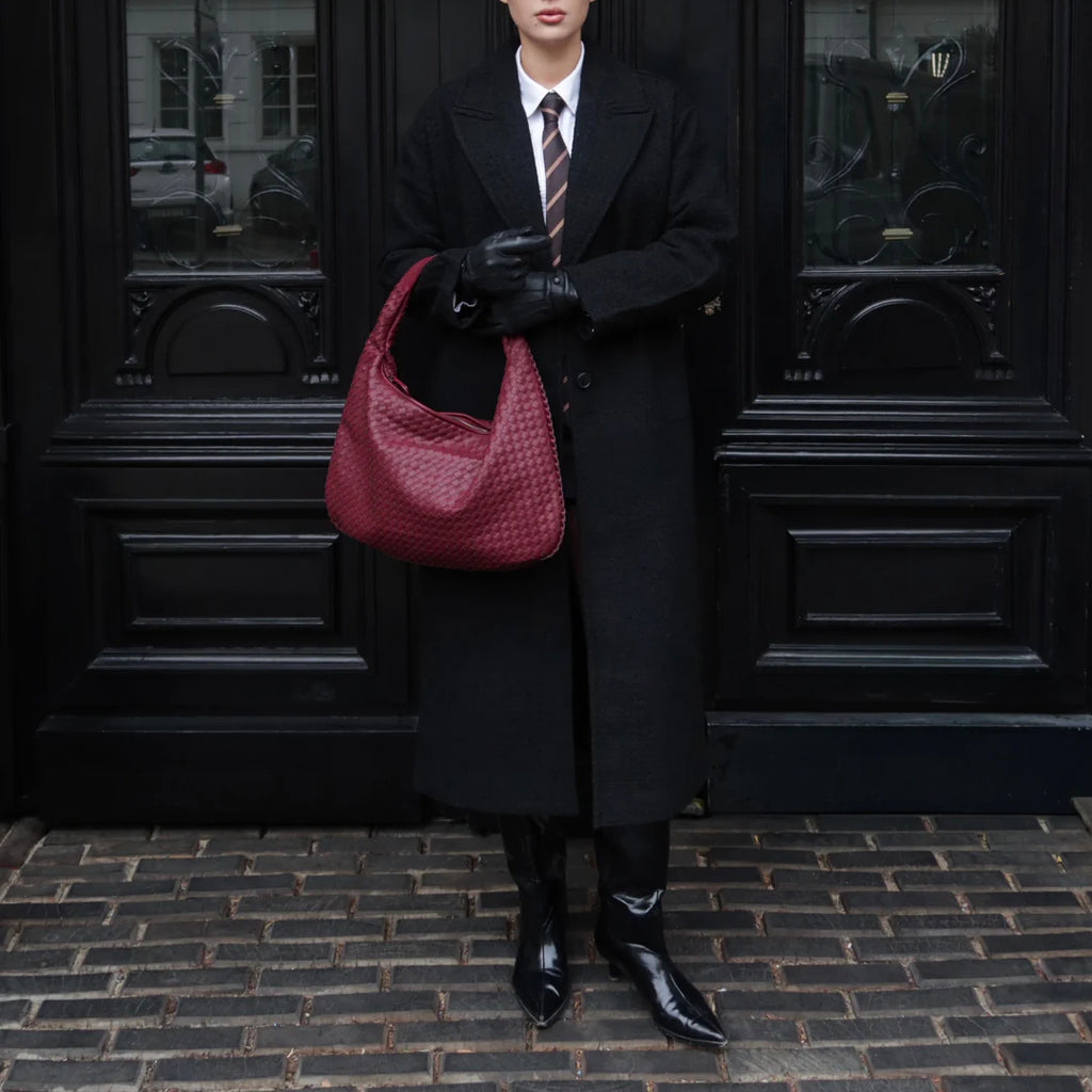women carrying woven hobo shoulder bag black coat street style