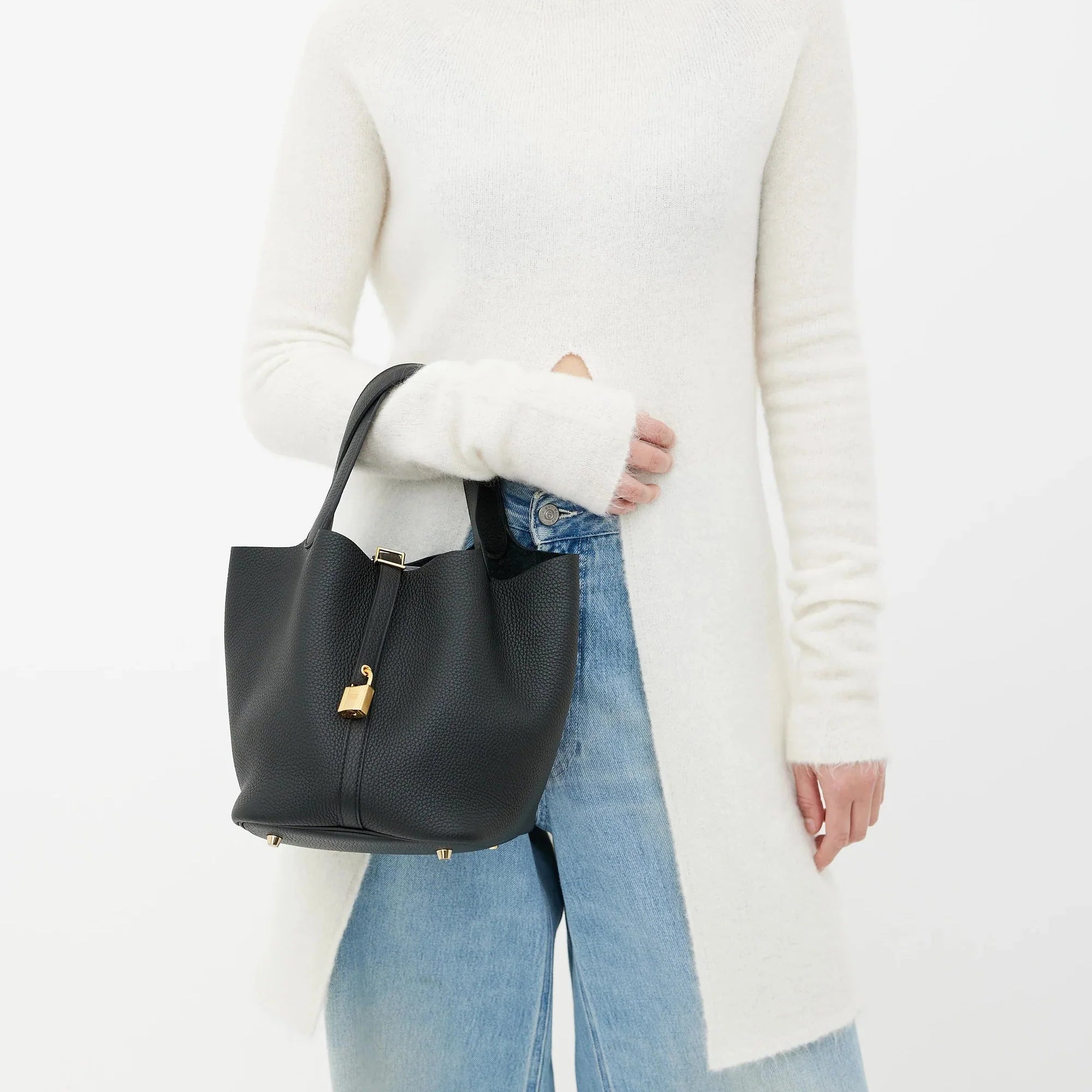 women carrying black bucket bag gold padlock street style elegant