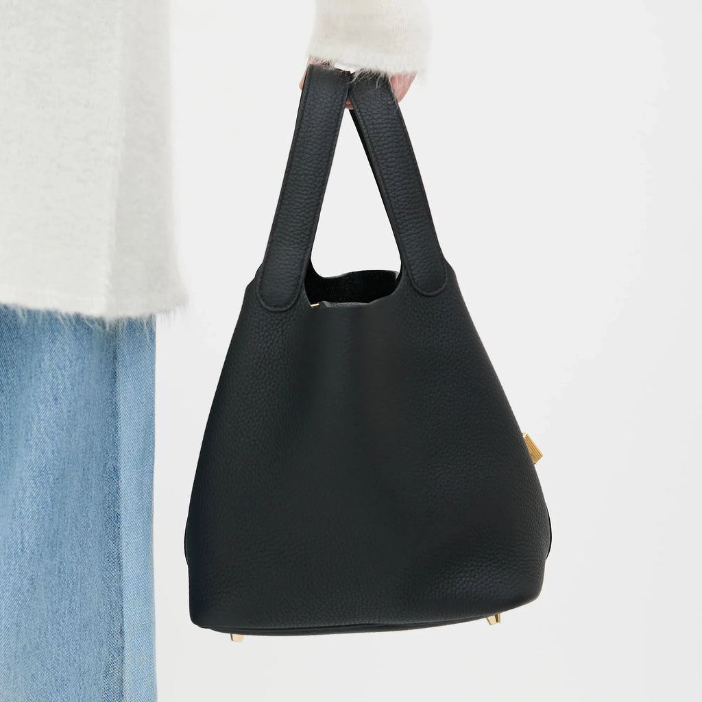 women carrying black leather bucket bag shoulder street style